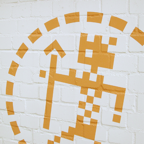 Pixelmann mit Pfeil in Orange an einer weißen Mauer.