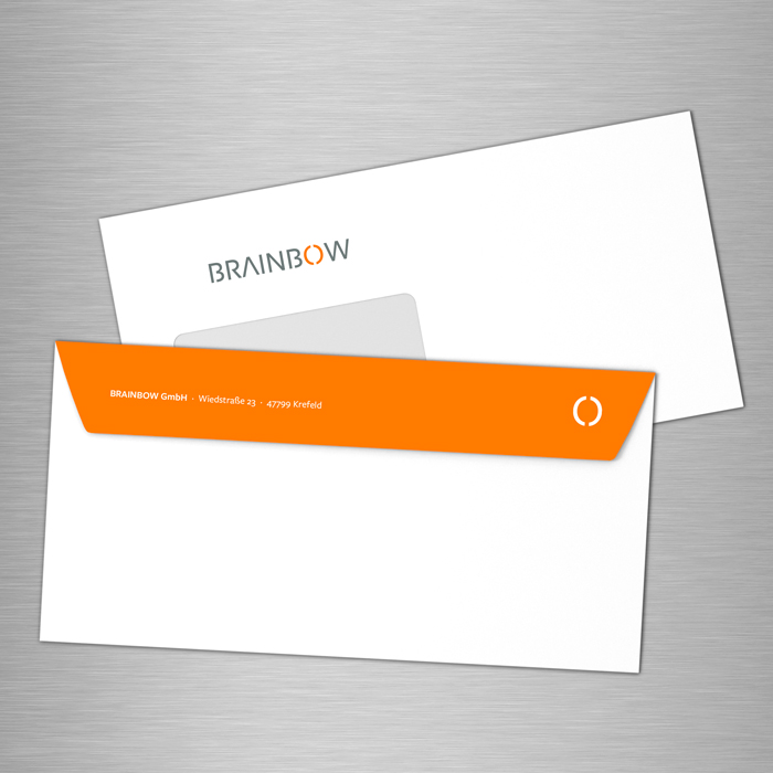 Kunde Brainbow: Kuvert im neuen Corporate Design mit Verschlusslasche in orange