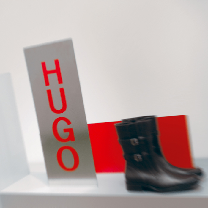 Kunde Hugo Boss: Hugo Logo Aufsteller mit Schuh daneben